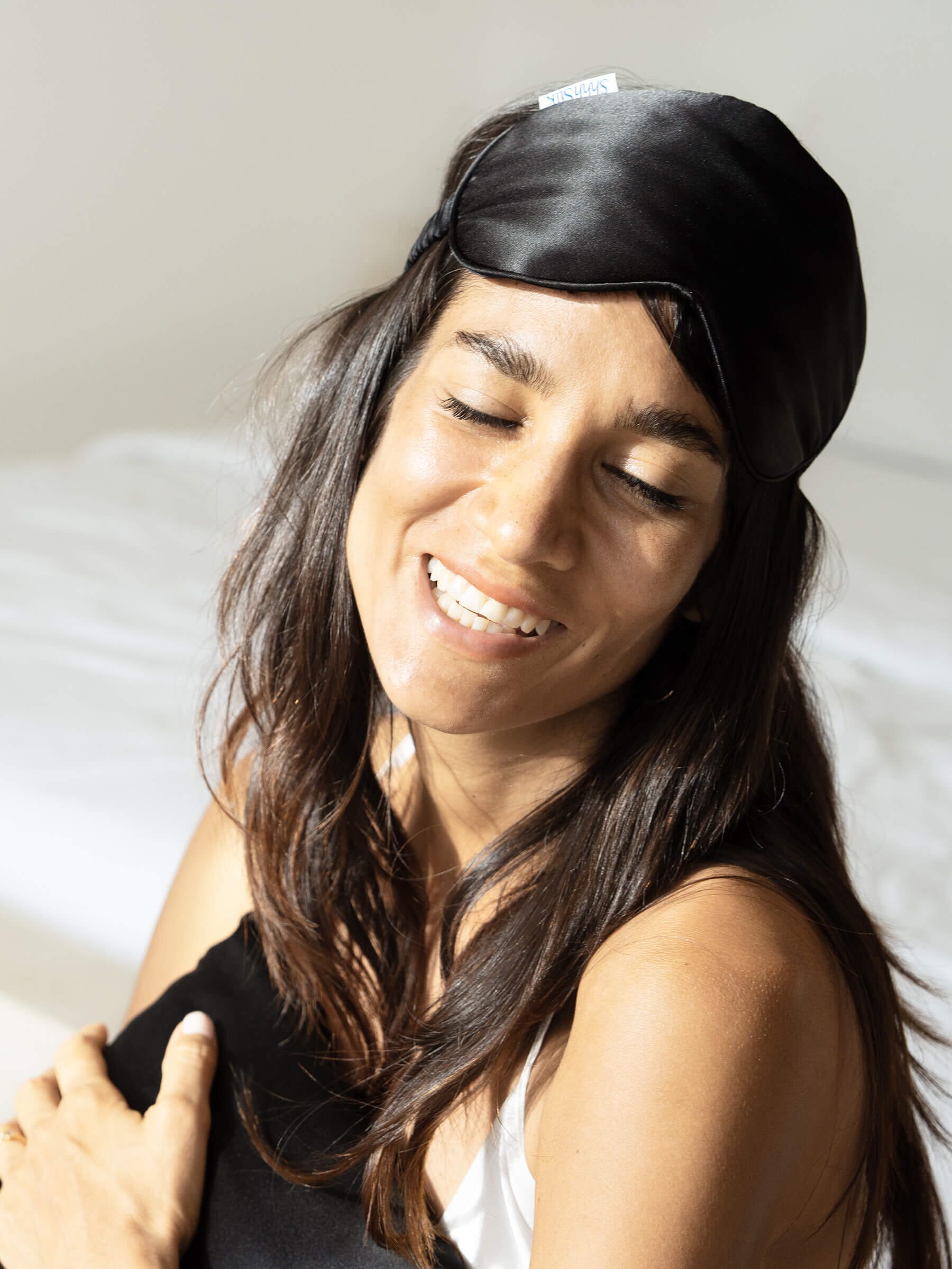Woman wearing a black silk sleep mask