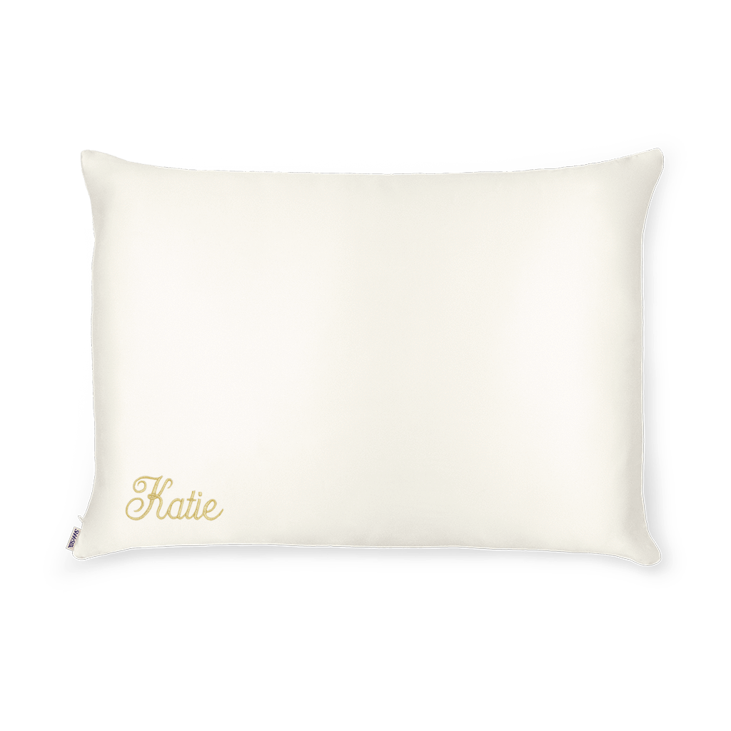 A white silk pillowcase with the name 'Katie' embroidered on the bottom left.